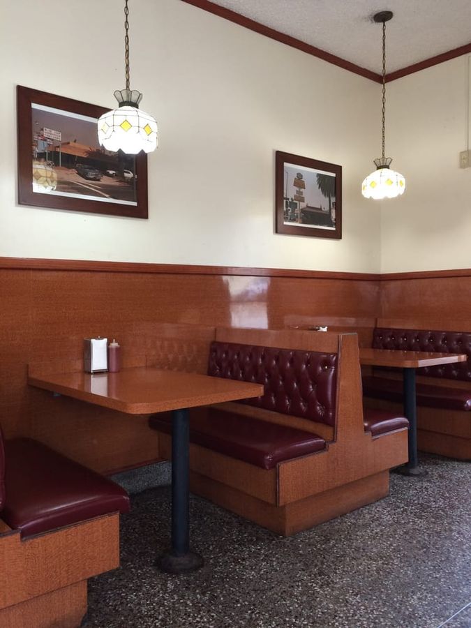 Inside Pete&rsquo;s Blue Chip: red tufted leather booths, wood paneling, and stained-glass hanging lamps